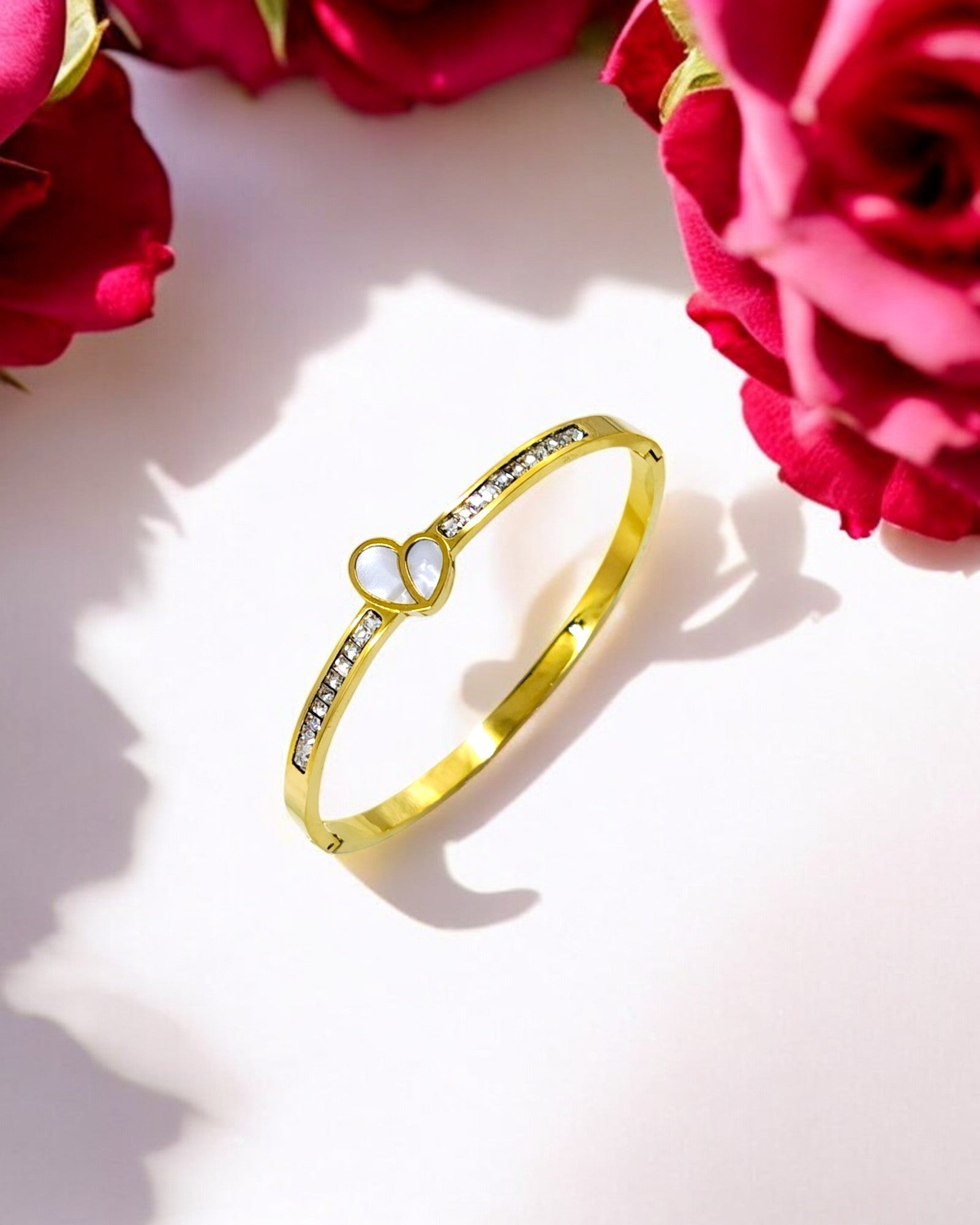 Elegant gold plated bracelet adorned with a white heart centerpiece and sparkling CZ stones, perfect for adding charm to both everyday looks and special occasions