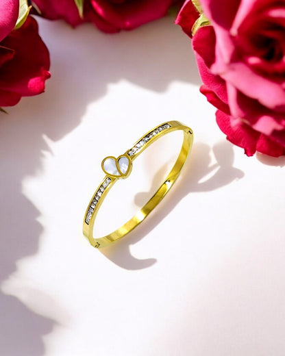 Elegant gold plated bracelet adorned with a white heart centerpiece and sparkling CZ stones, perfect for adding charm to both everyday looks and special occasions