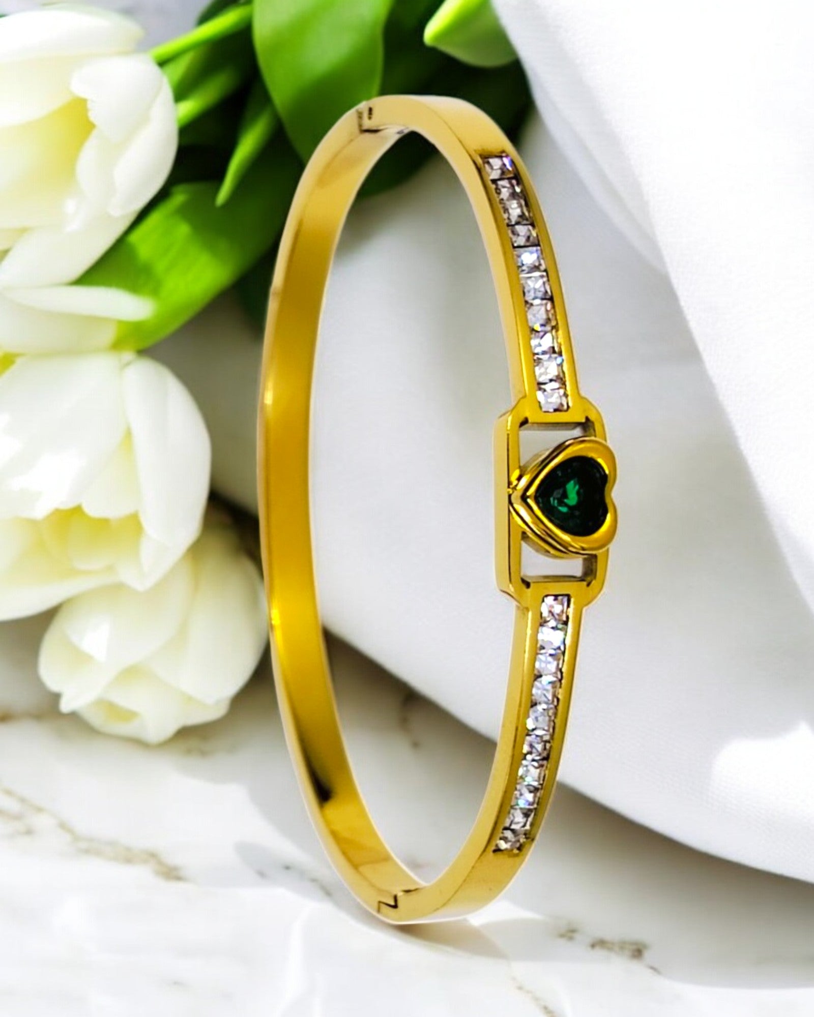 Elegant gold plated bracelet with green heart centerpiece and studded CZ stones, perfect for parties, weddings and everyday wear.