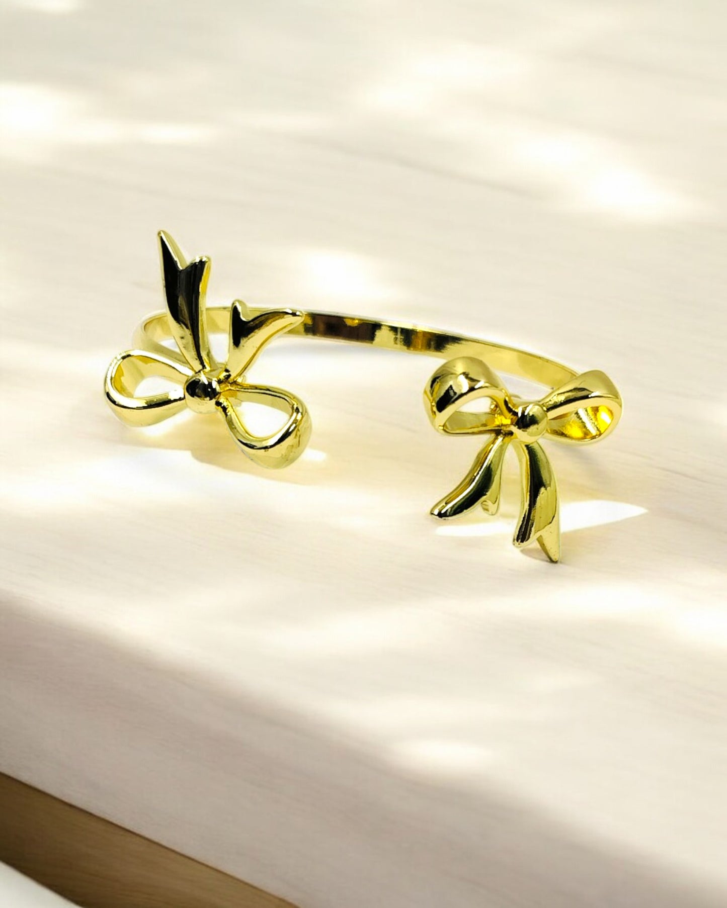 Stylish gold plated open bracelet with dual bow design, trendy women’s jewelry perfect for parties, gifting and daily wear.