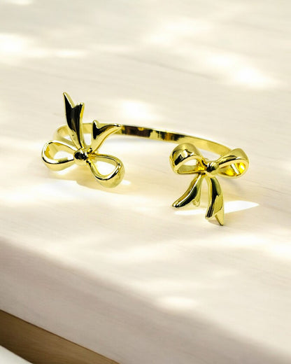 Stylish gold plated open bracelet with dual bow design, trendy women’s jewelry perfect for parties, gifting and daily wear.
