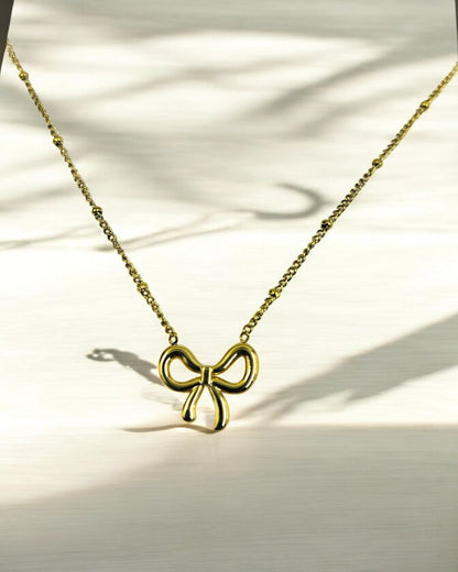 Elegant gold plated bow pendant necklace for women, minimalist lightweight jewelry perfect for casual and festive wear.