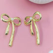 Chic gold bow stud earrings with pearl accents, feminine and stylish design perfect for everyday wear or gifting.