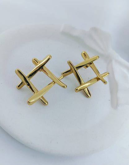 A pair of gold-plated stainless steel hashtag stud earrings displayed on a white surface.