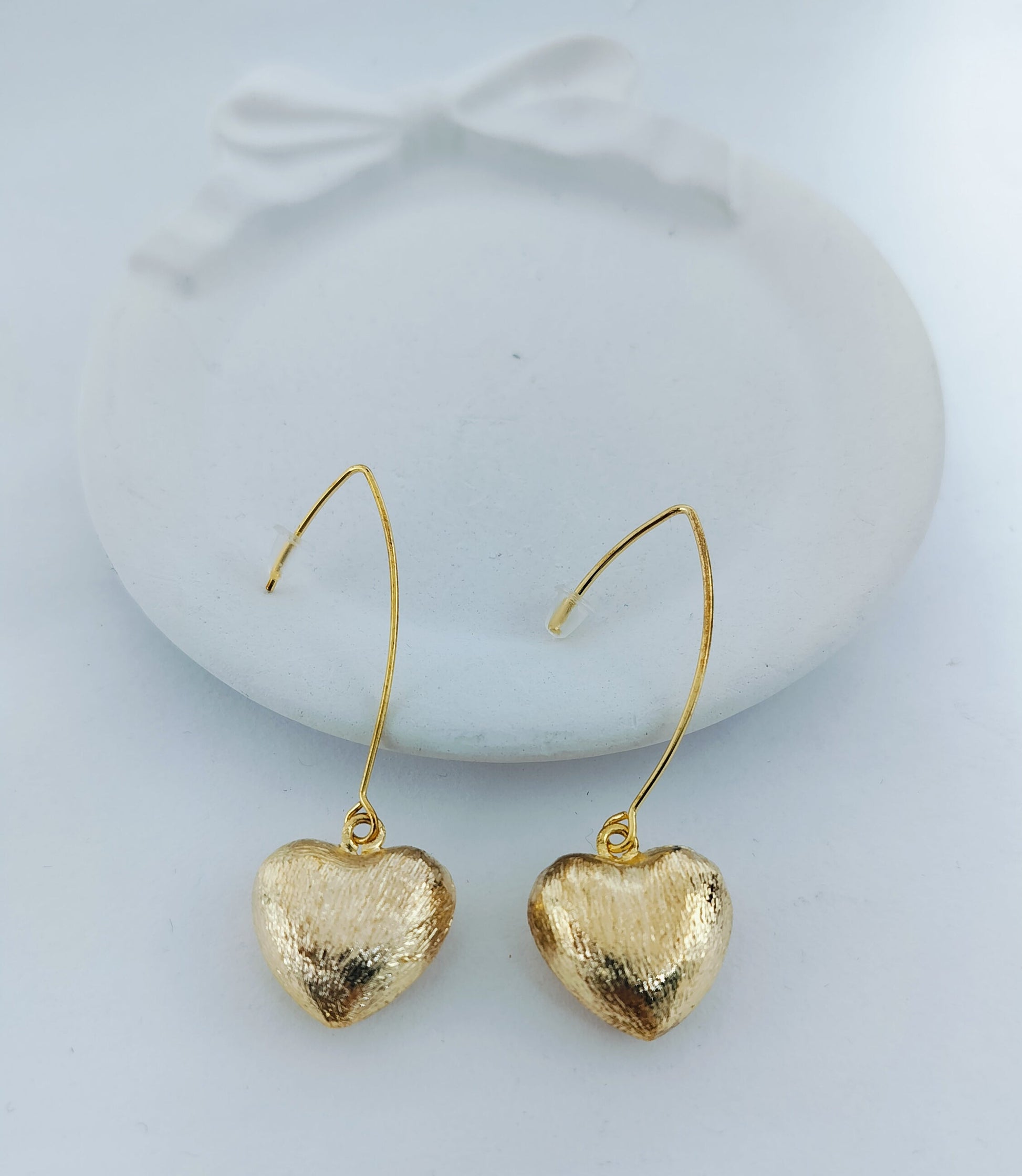 Elegant gold heart shaped dangle earrings with textured finish, perfect for women’s fashion jewelry and gifting