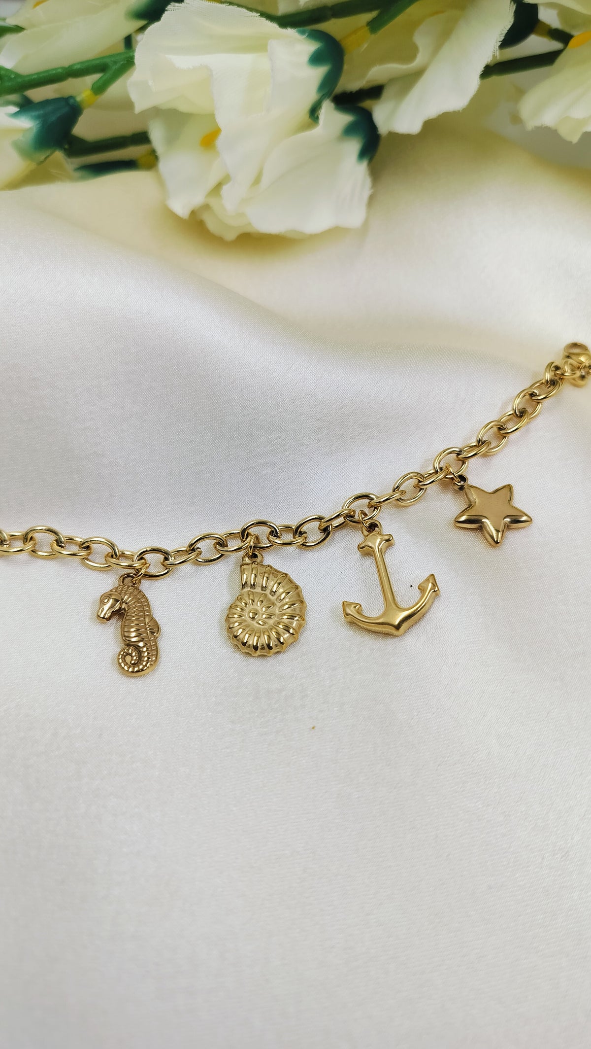 Delicate gold charm bracelet with seahorse, sun, anchor and star pendants – trendy ocean inspired jewelry for women