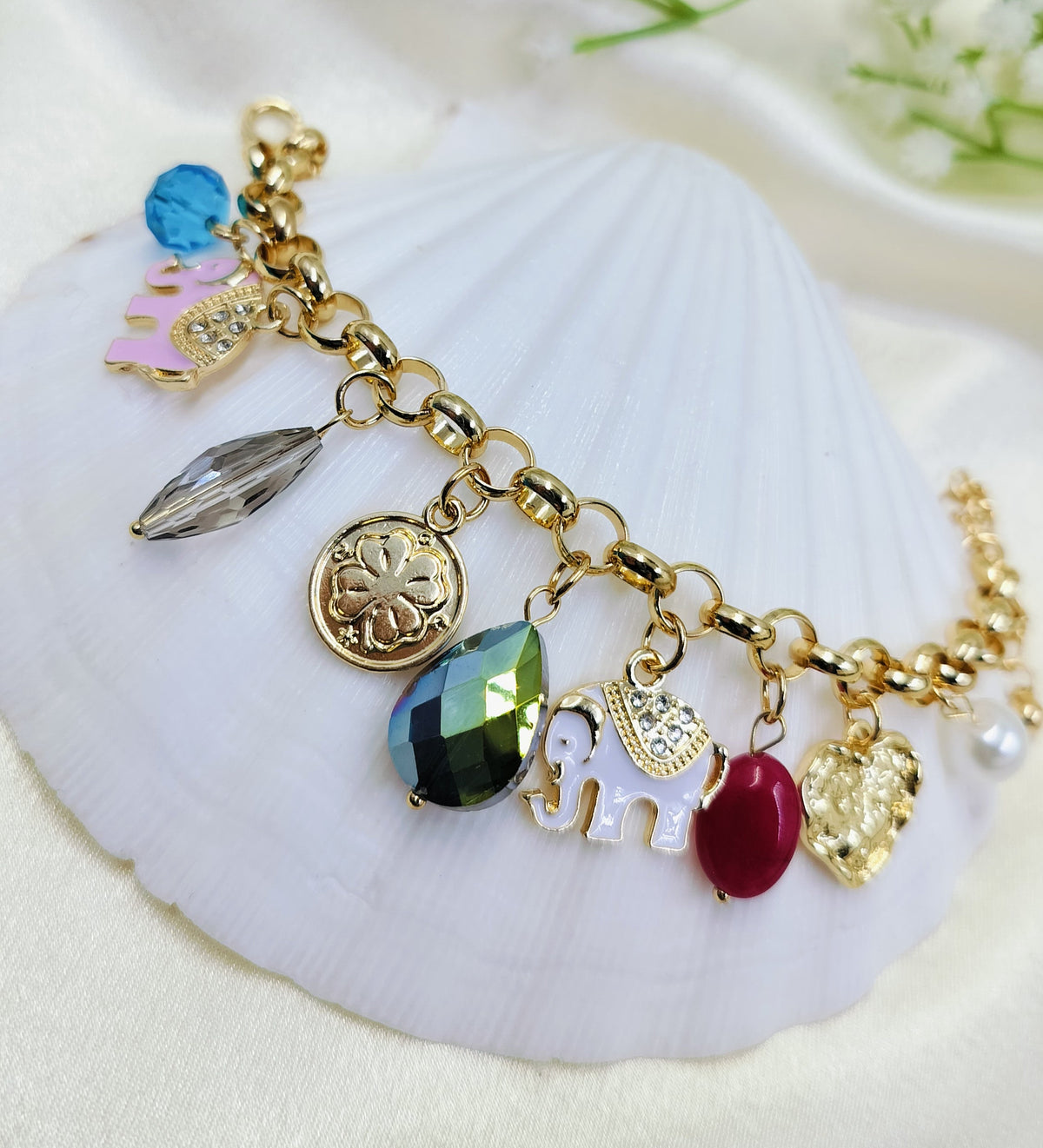 Gold charm bracelet with colorful gemstones, enamel elephant charms, and designer pendants for women