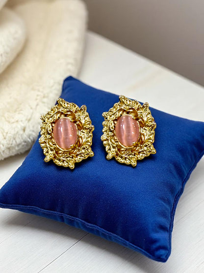 Gold plated stud earrings with oval pink gemstone displayed on blue velvet cushion – Glampouch jewelry