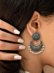 Close-up side view of one oxidised silver chandbali earring on a model ear with dark hair