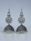 Front view of oxidised silver floral kundan jhumka earrings with engraved dome and pearl fringe on grey background