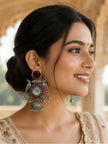Model wearing oxidised silver peacock jhumka earring with bun hairstyle and embroidered ethnic outfit
