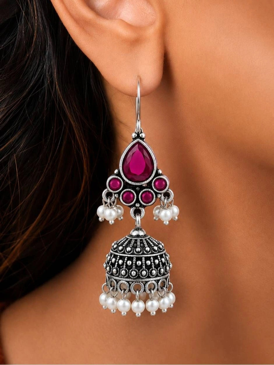Single oxidised silver ruby jhumka earring worn on a woman's ear showing the full hanging length