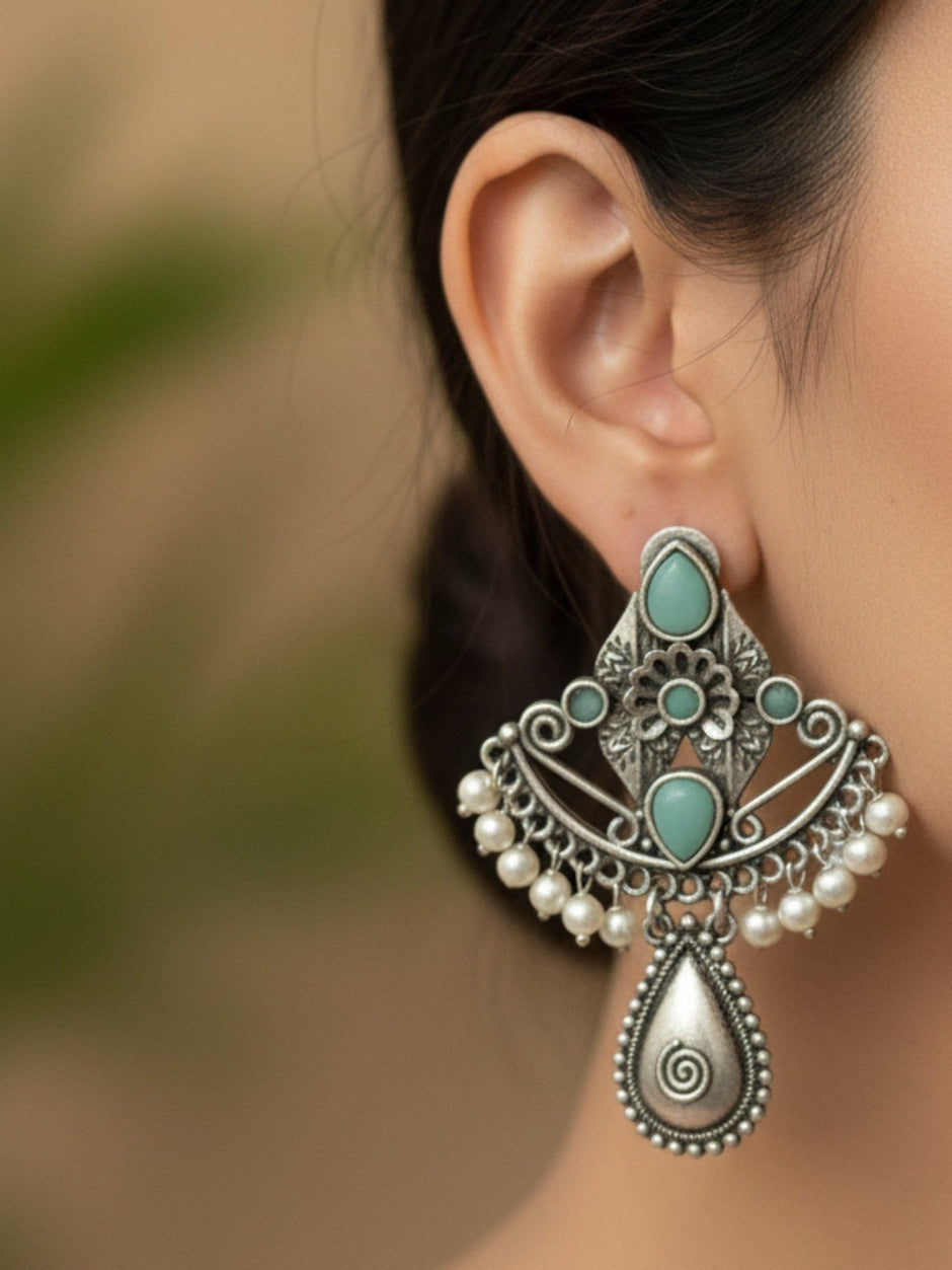 Oxidised silver turquoise pearl drop earring worn on a woman's ear showing full length and scale