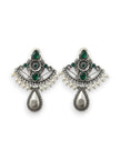 Pair of oxidised silver chandbali earrings with green stones and white pearl drops on white background