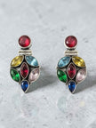 Close-up of oxidised silver multi-stone drop earrings showing red, blue, green and yellow crystals on grey background