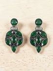 Front view of green stone oxidised silver cluster earrings displayed on a light wood background