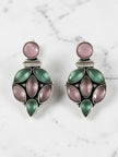 Close-up of oxidised silver floral cluster drop earrings with pink and green stones on white marble