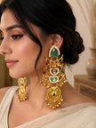 Woman wearing large gold kundan chandbali earring with layered crescent tiers and pearl borders on a cream saree