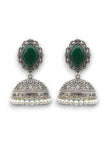 Pair of oxidised silver green stone jhumka earrings with engraved dome and pearl drops on a white background