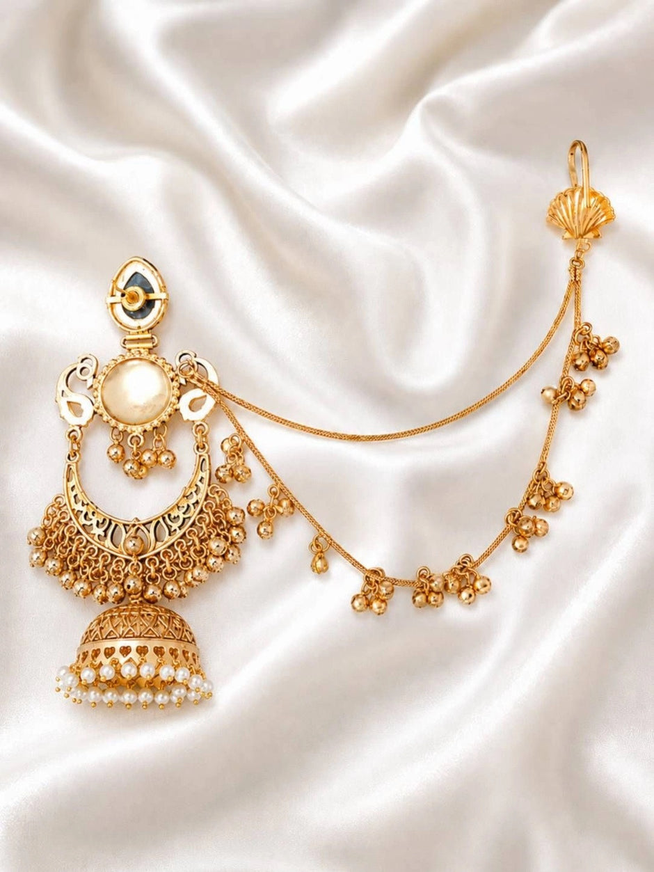 Gold-plated chandbali jhumka earring with large pearl centre, intricate filigree crescent and pearl-drop jhumka bell on white satin