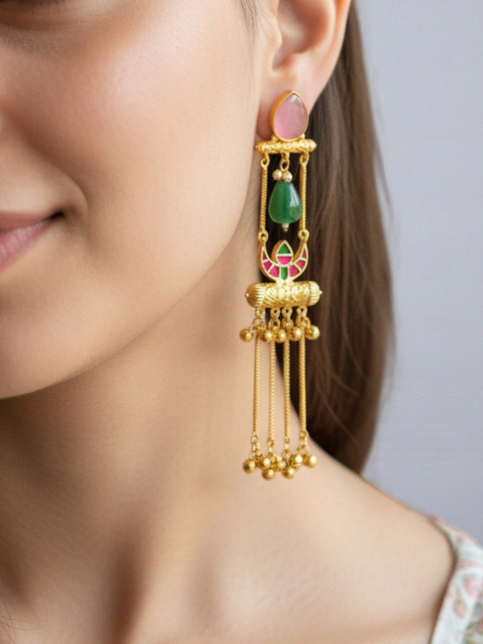 Gold-plated meenakari tassel jhumka earring worn on a woman's ear showing full length and pink stone top