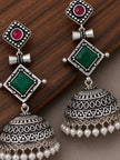 Two oxidised silver jhumka earrings displayed on a wooden surface showing full geometric layered design