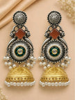 Pair of dual-tone jhumka earrings with oxidised silver upper, green kundan centre, pearl fringe and gold dome bell, laid flat