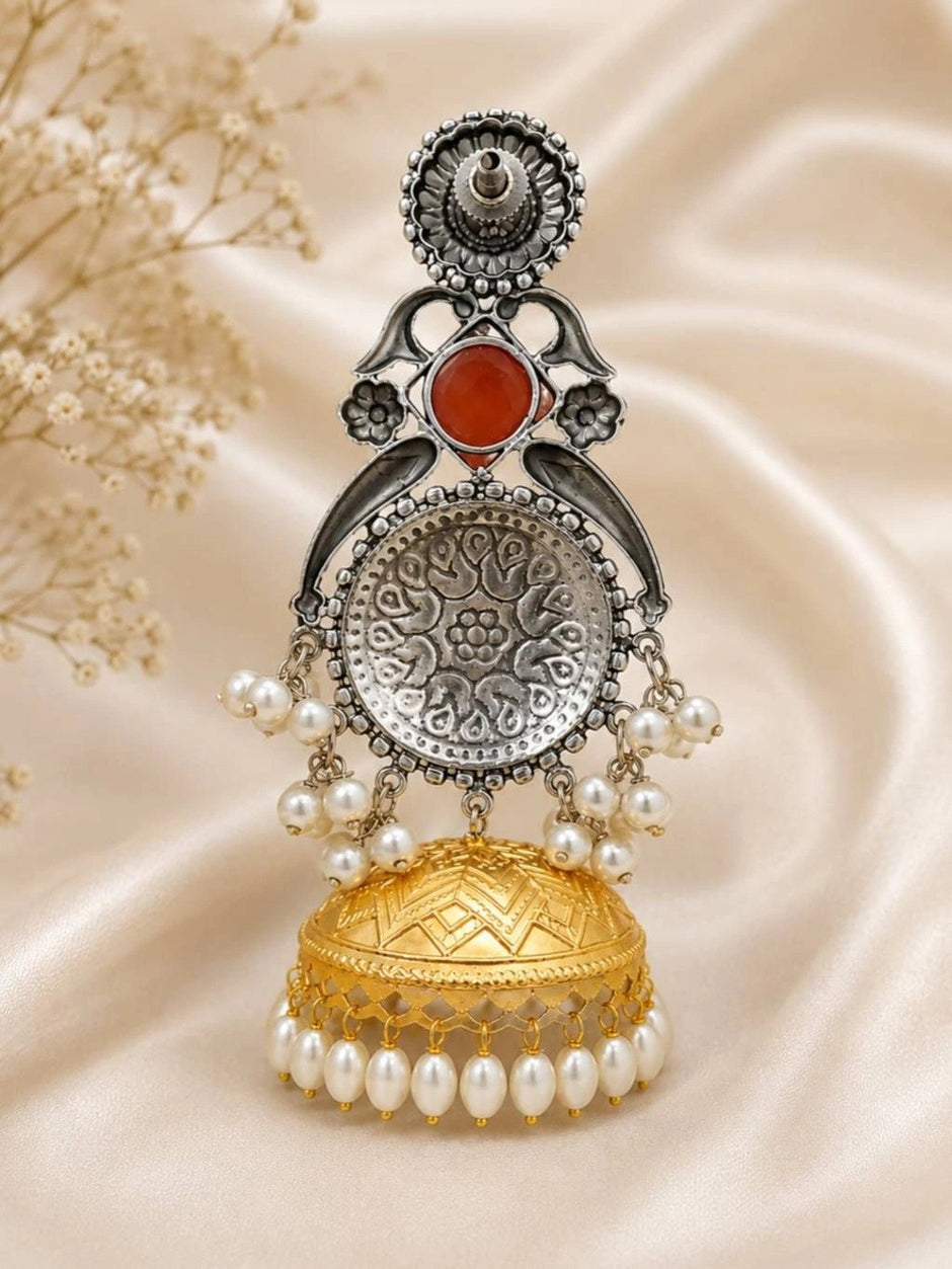 Single jhumka earring standing upright showing oxidised silver medallion back and gold dome bell with pearl border
