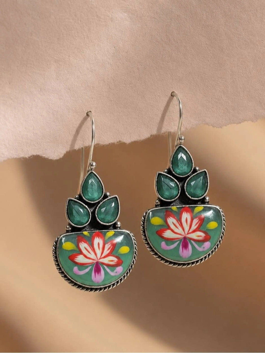 Pair of oxidised silver meenakari hook earrings with green teardrop stones and hand-painted lotus on teal enamel base