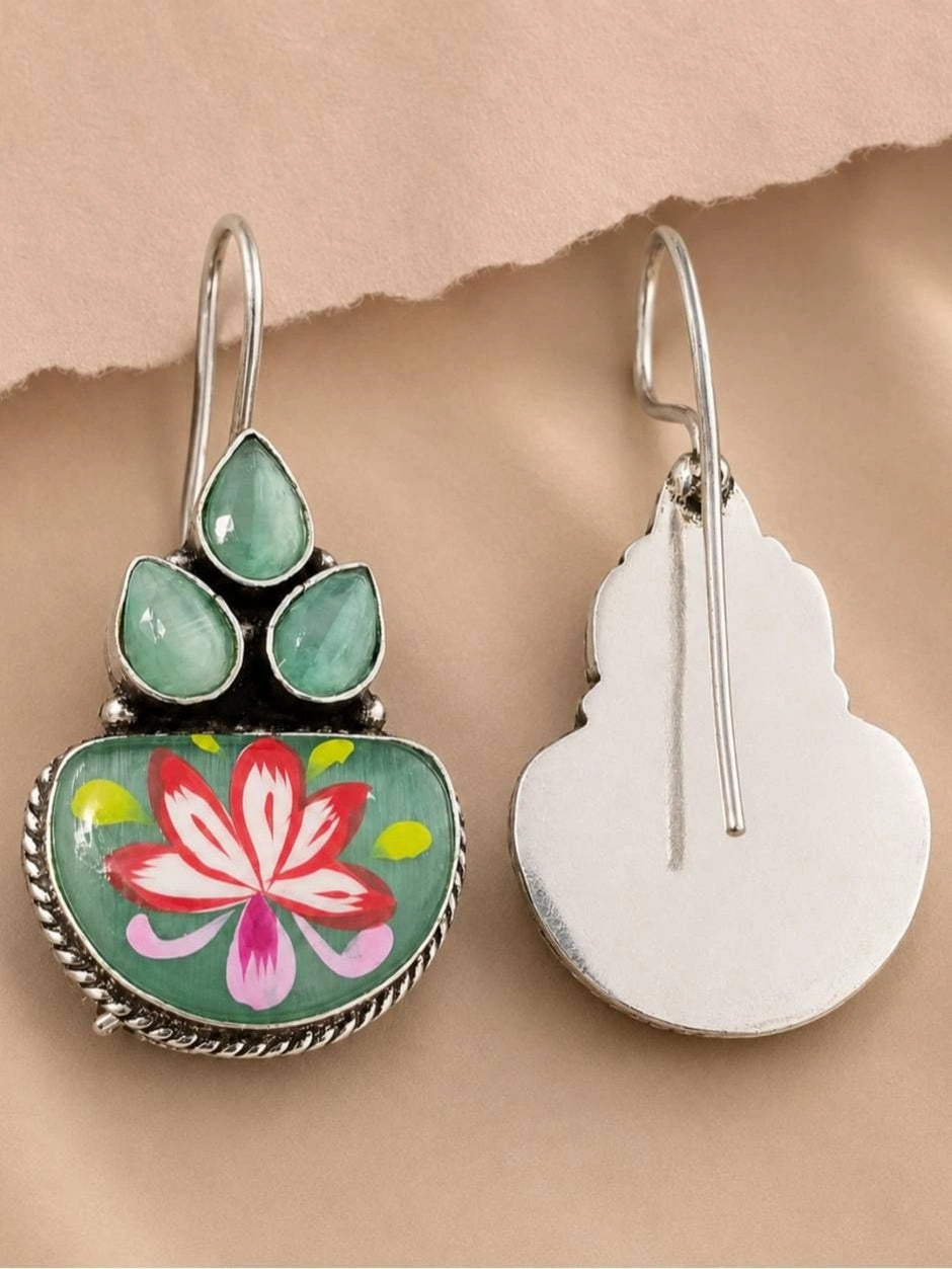 Front and back view of meenakari hook earrings showing painted lotus face and plain silver metal reverse