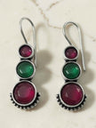 Oxidised silver three-stone drop earrings with shepherd-hook wires on a marble background