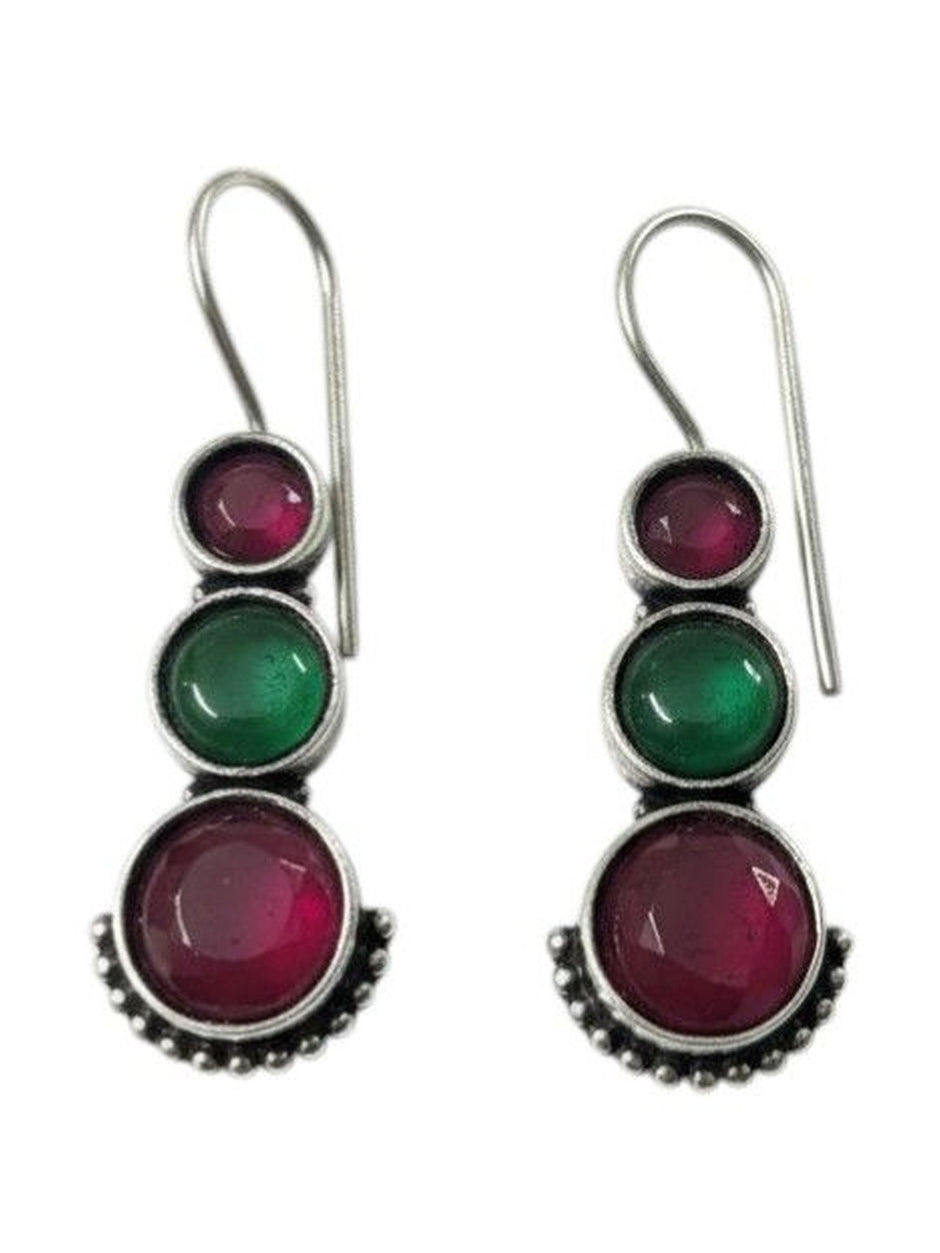 Front view of oxidised silver graduating stone drop earrings showing ruby-pink and green cabochons on white background
