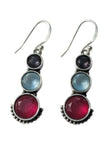 Close-up of silver drop earrings with three graduated coloured stones and dotted beadwork detail on white background
