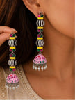 Model wearing long oxidised silver geometric jhumka earrings with pink enamel dome and pearl drops at the ear