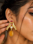 Model wearing gold-plated love birds earring with amber resin drop close up on ear