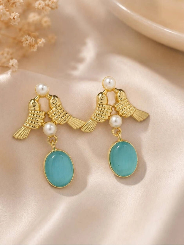 Pair of gold-plated lovebird drop earrings with pearl accents and aqua oval stone on satin fabric