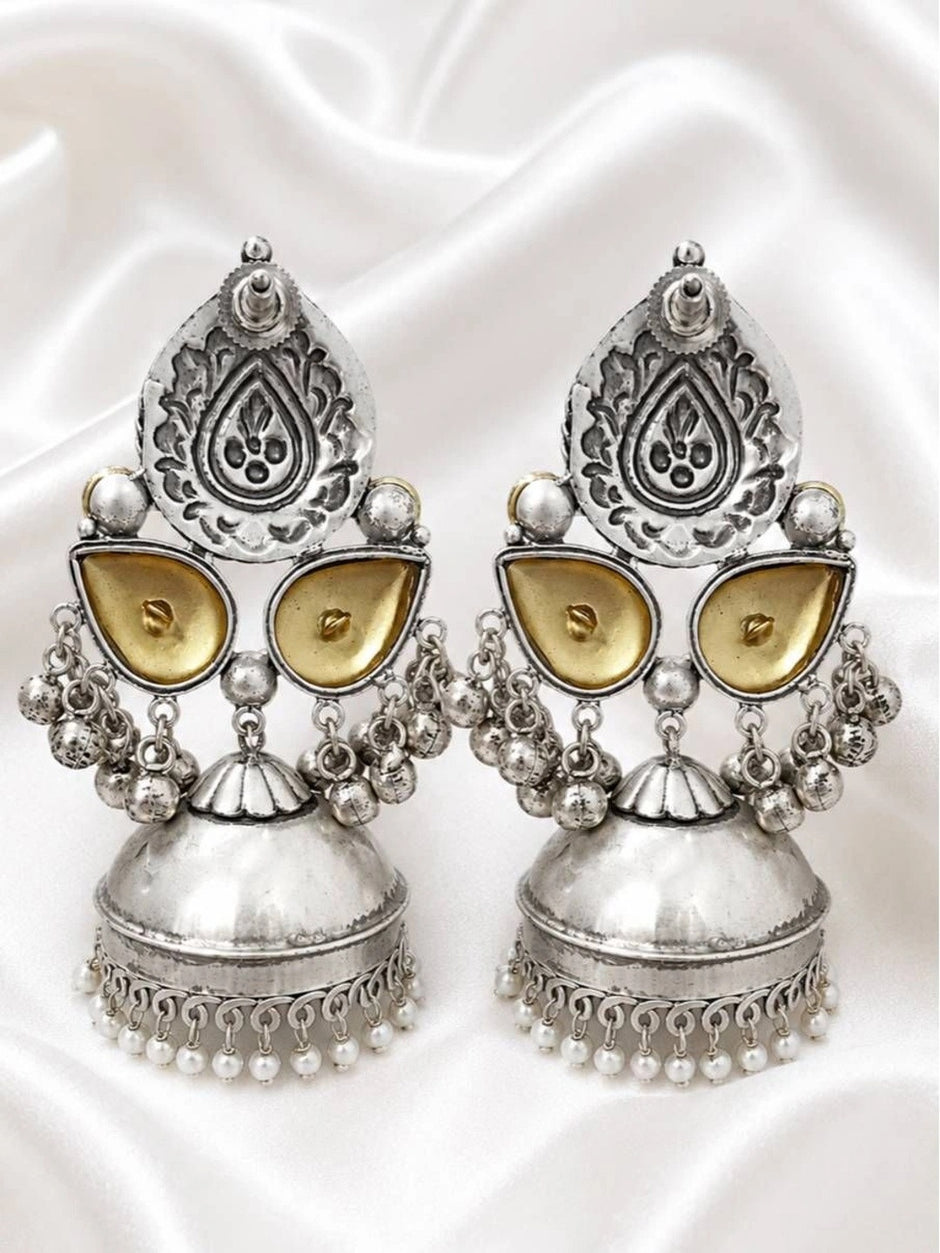 Back view of oxidised silver jhumka earrings on white satin showing reverse engraving and stud fitting