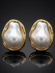 Pair of gold-plated baroque pearl stud earrings on dark reflective surface