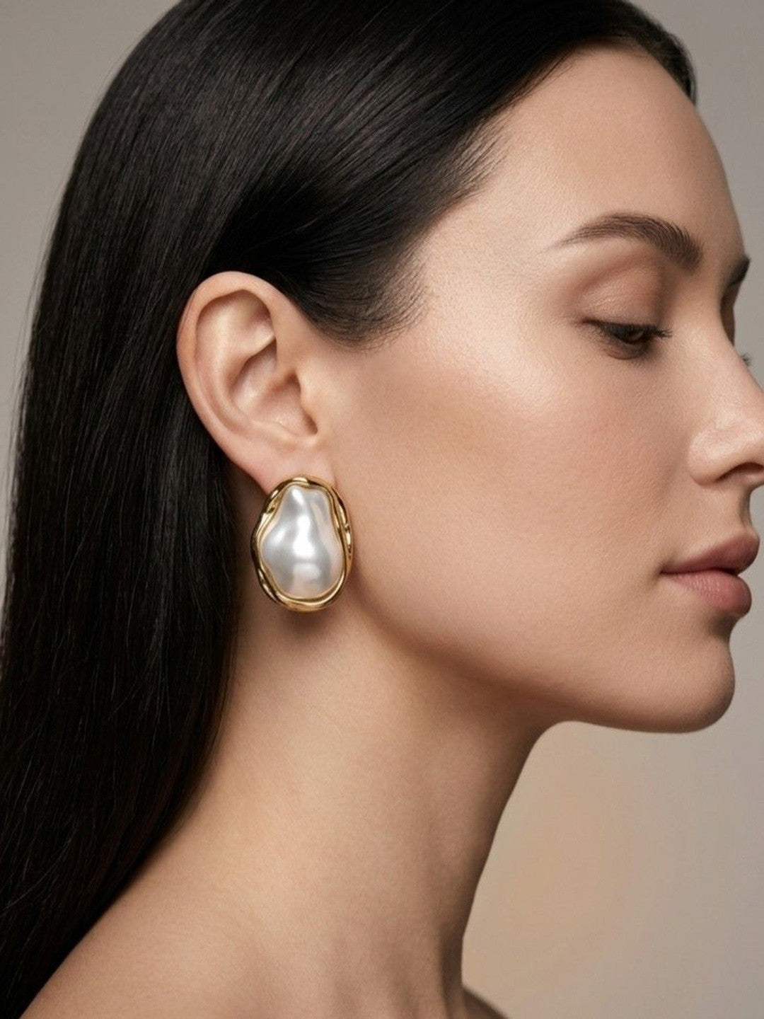 Model wearing gold baroque pearl stud earring shown in close side profile