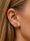 Gold triple-hoop earring worn on model with blonde hair showing front-facing crescent silhouette