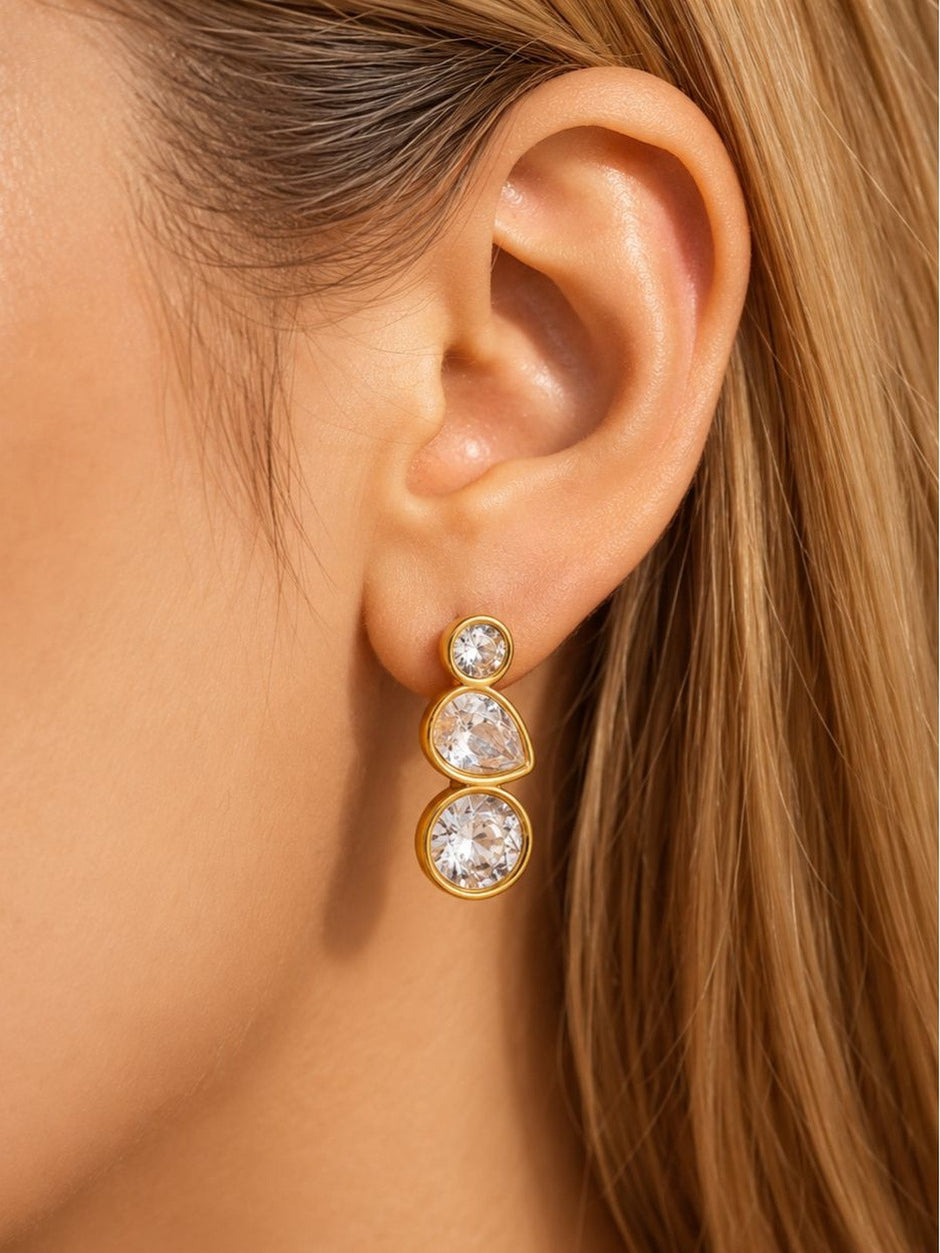 Gold-plated crystal drop earring worn on a blonde model showing side profile of the ear