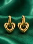 Pair of gold-plated open heart drop hoop earrings displayed on green satin fabric