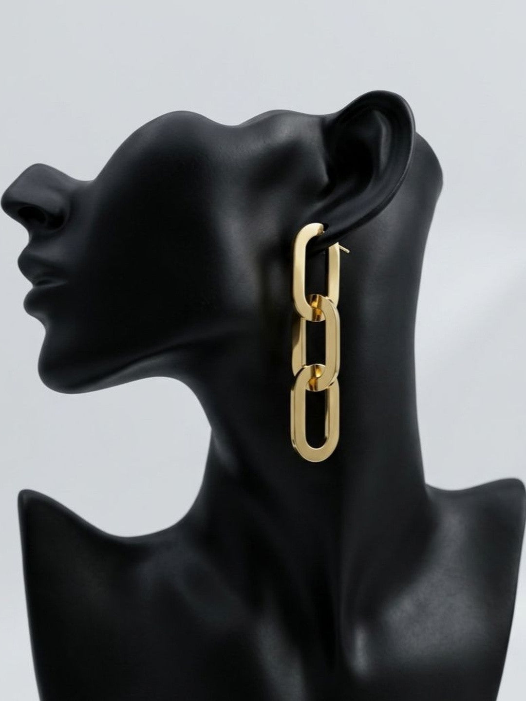 Gold-toned three-link oval chain drop earring displayed on a black jewellery bust, side profile view