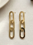 Pair of gold-toned chain link drop earrings laid flat on a cream linen background showing stud posts