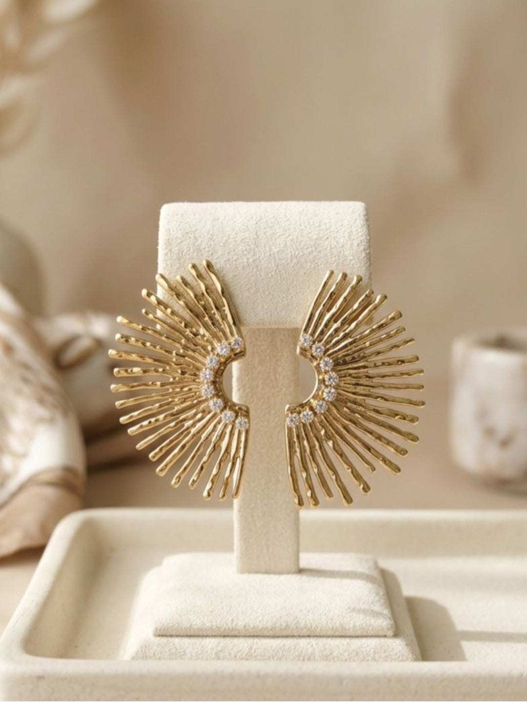 Both gold fan stud earrings displayed upright on a cream velvet jewellery stand showing full silhouette