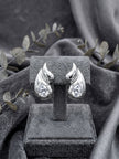 Silver flame wing crystal stud earrings displayed on a grey velvet jewellery stand with eucalyptus sprigs