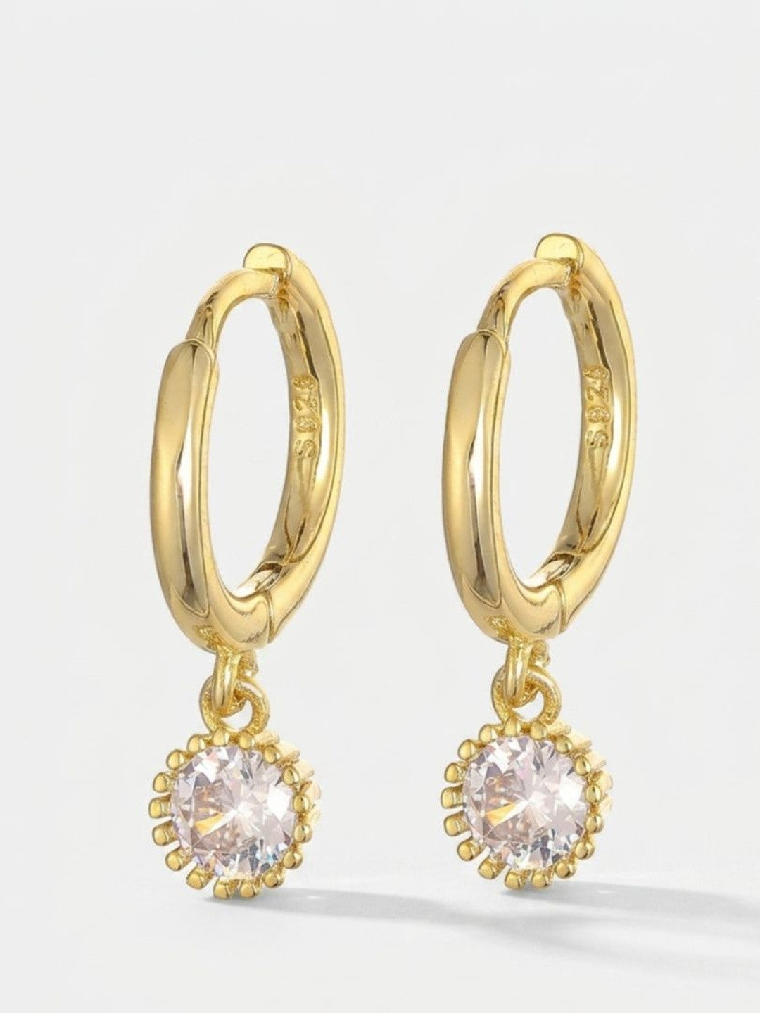 Pair of gold-plated S925 hoop earrings with round crystal solitaire charm pendants on white background