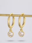 Two gold-plated crystal charm hoop earrings hanging from a brass display rod