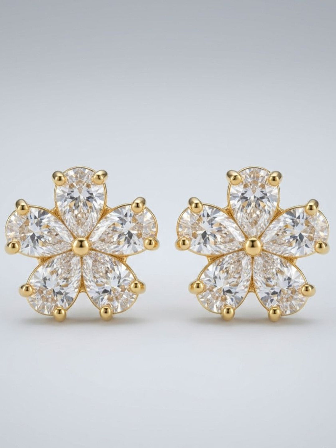 Close-up render of gold-plated CZ flower stud earrings showing pear-cut stone detailing