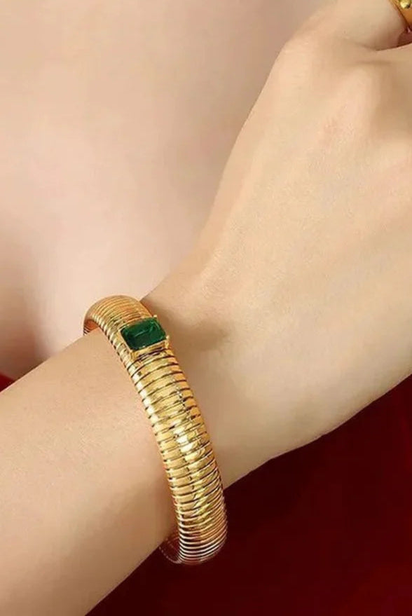 Bold yet timeless – gold plated flexible bangle adorned with a deep green emerald-cut stone, designed to elevate your everyday and festive looks.